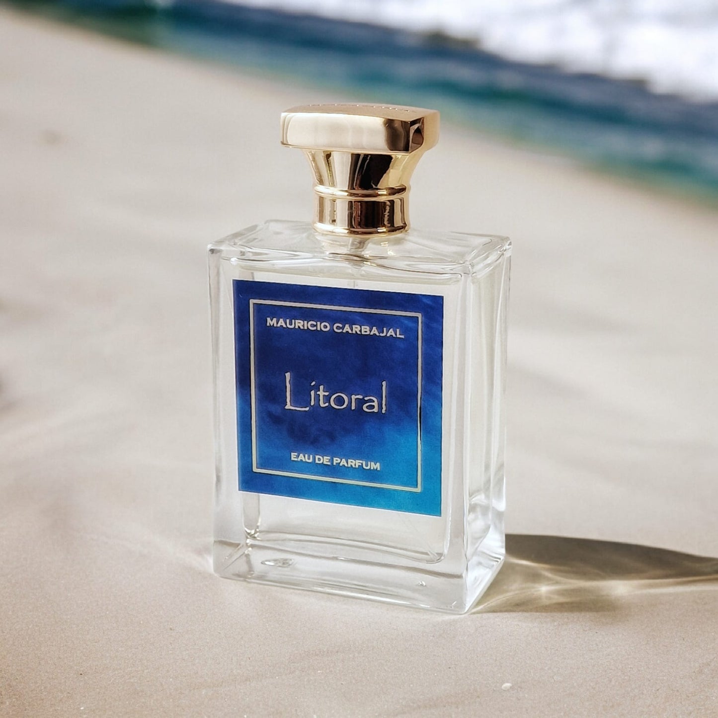 frasco del perfume Litoral en la arena junto al mar 